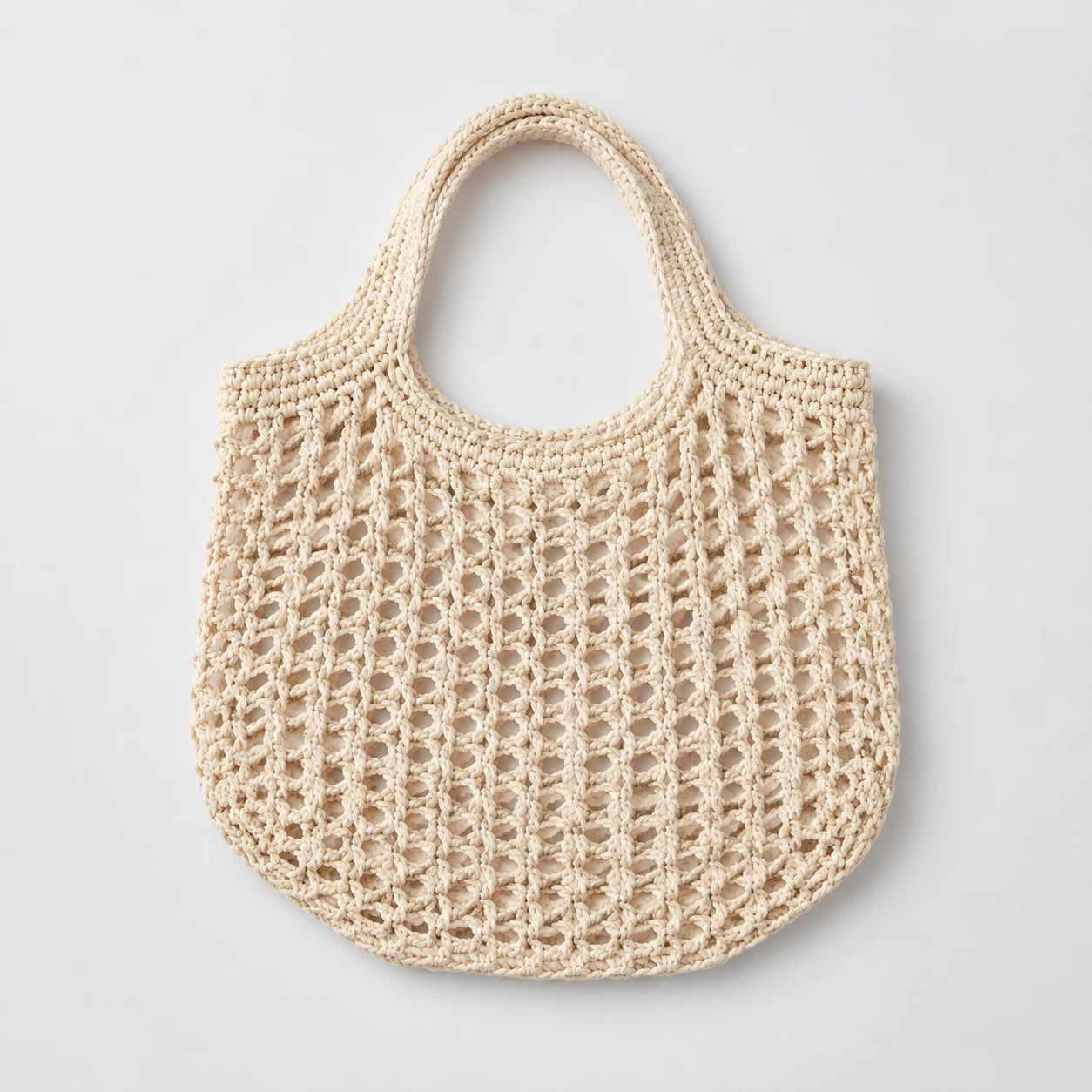 Ivory crochet market tote on a pale studio background, product concept